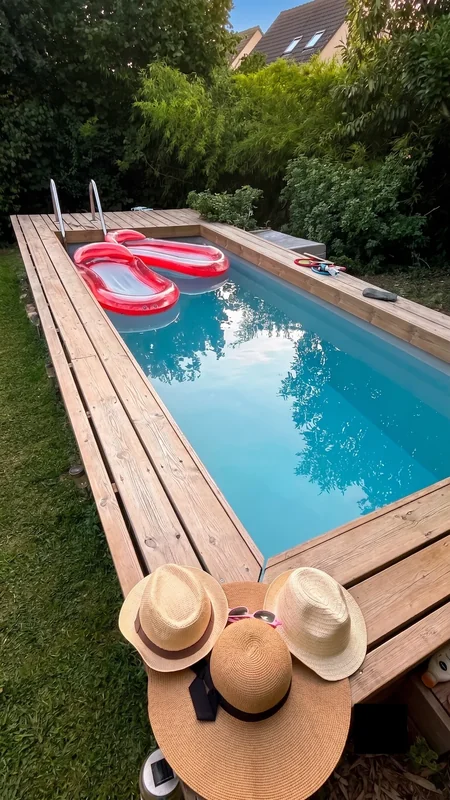 Piscine avec bouée gonflable rouge et chapeaux de paille dans le jardin de Sarcelles
