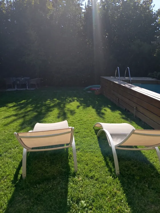 Transats à l'ombre face à la piscine en bois du jardin de Sarcelles